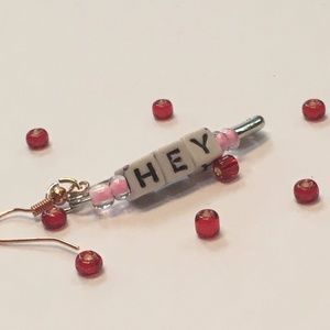 Pink earrings with the word hey